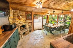 a dining room with a table and a stone fireplace at Вила Бучала Villa Buchala in Dyakovo