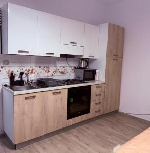 a kitchen with white cabinets and a stove top oven at Studio Apartman Jovičić in Bjelovar