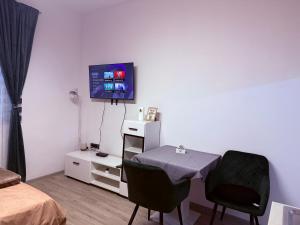 a room with a table and a tv on a wall at Studio Apartman Jovičić in Bjelovar