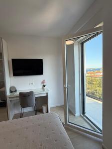 a bedroom with a bed and a desk and a window at Villa Omorfia - SEVID in Sevid