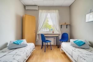 a bedroom with two beds and a desk and a window at Jūras Vilks in Ventspils +81 photos