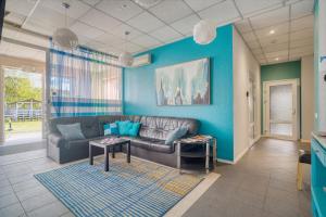 a living room with a couch and a blue wall at Jūras Vilks in Ventspils