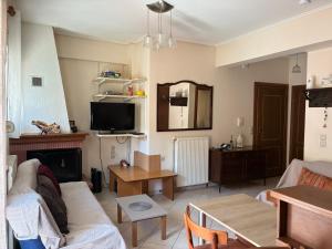 a living room with a couch and a table at Basis Apartment in Karpenisi +5 photos