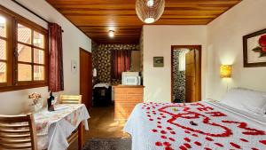 a bedroom with a bed and a table and a microwave at Pousada Florada do Amanhã in Monte Verde +197 photos