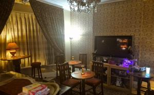 a living room with two tables and a flat screen tv at Northdene Theatre Hotel in Blackpool