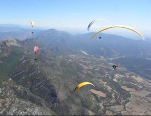 a group of kites flying over a mountain at Cal Robert in Penellas