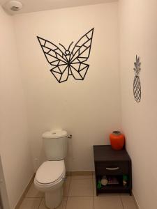 a bathroom with a toilet and a pineapple on the wall at Maison au calme in La Roche-sur-Yon +21 photos