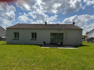 a small white house with two chairs in a yard at Maison au calme in La Roche-sur-Yon