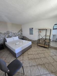 a bedroom with a bed and two chairs in it at Pension Assos in Koinyra