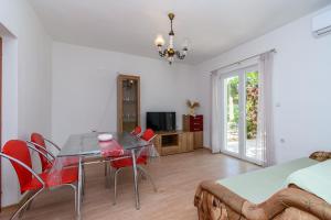 a bedroom with a dining room table and red chairs at Apartments Ian in Lopar