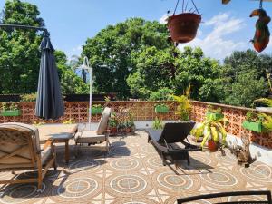 an outdoor patio with chairs and an umbrella at Roof Garden 3 in Coatepec