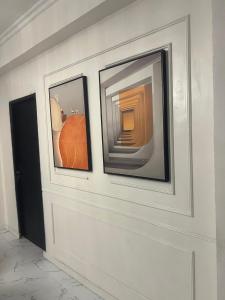 three pictures on a wall in a room at Ivaeli Apartment in Lagos
