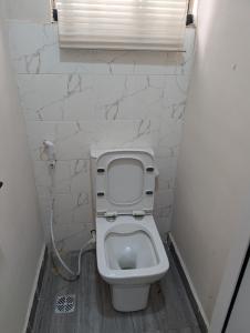 a small bathroom with a toilet with a window at Ivaeli Apartment in Lagos