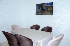 a white table and chairs with a tv on the wall at إقامة جنان فاس in Fez
