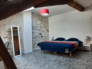 a bedroom with a bed and a brick wall at Bords de Loire in Les Ponts-de-Cé