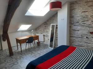 a bedroom with a bed and a desk and a skylight at Bords de Loire in Les Ponts-de-Cé