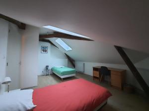 a bedroom with a red bed and a desk at Bords de Loire in Les Ponts-de-Cé