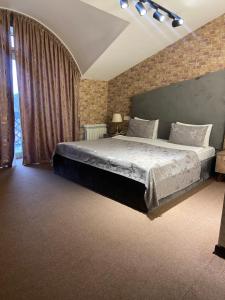 a bedroom with a large bed with a brick wall at TALA ROOMS Hotel in Zaqatala