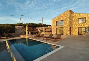 a house with a swimming pool next to a building at Izel Villas in Skinária