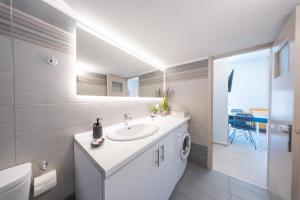 a white bathroom with a sink and a toilet at Socratous Apartments in Mytilene +50 photos