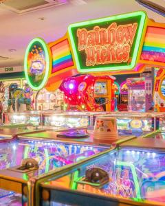 a pinball machine with a rainbow colored sign in a casino at Wilson Getaways - Caravan Hire in Rhyl