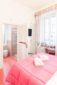 ローマにあるディバイン ベッド & ブレックファーストのバスルーム付きの客室で、大型ピンクベッド1台を利用します。