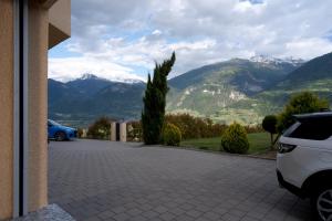 a car parked in a driveway with mountains in the background at Maison les Mésanges in Flanthey