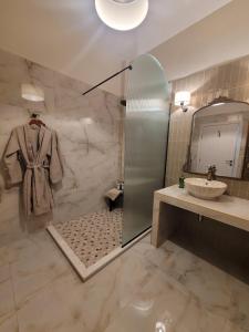 a bathroom with a shower and a sink and a mirror at City Center Suites in Karpathos