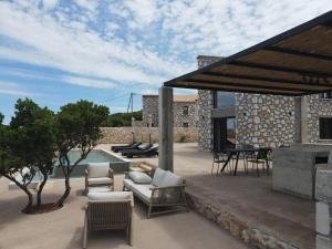a patio with couches and chairs and a pool at Izel Villas in Skinária