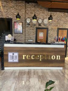 a reception desk in a building with clocks on the wall at TALA ROOMS Hotel in Zaqatala