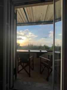 a balcony with a view of a table and chairs at Golden Hour on the Hill in Aegina