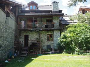 an old stone house with a tennis court in front of it at Rifugio Escursionistico Vernin in Fenils