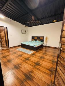 a bedroom with a bed and a wooden floor at The cosmos farm in Gurgaon