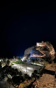 a castle on top of a mountain at night at La pineta Apartment Tropea in Tropea