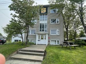 a building with a picnic table in front of it at Maison de chambres - Édifice Le SAGE in Shawinigan