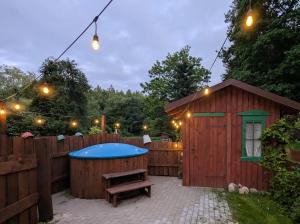 a wooden shed with a bench next to a fence at Piecówka in Kaczkowo +44 photos
