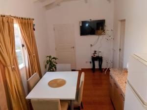 a dining room with a table and a tv on the wall at Depto Muy Patagónico, lindo y cómodo in Trelew