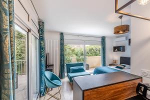 a living room with a blue chair and a couch at Appartement Chic, Climatisation et Piscine in Ormoy-la-Rivière +18 photos