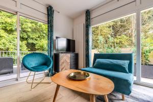 a living room with a couch and a table at Appartement Chic, Climatisation et Piscine in Ormoy-la-Rivière