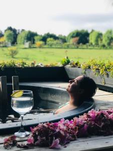 a woman in a bath tub with a glass of water at Alojamiento para 2 con tinaja in Calbuco