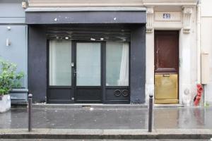 a building with a yellow door on a street at Souplex - 4P - Batignolles in Paris