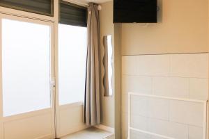 a bathroom with a sliding door and a window at Souplex - 4P - Batignolles in Paris