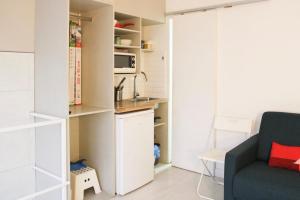 a living room with a couch and a kitchen at Souplex - 4P - Batignolles in Paris