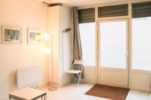 a room with a door and a chair and a table at Souplex - 4P - Batignolles in Paris