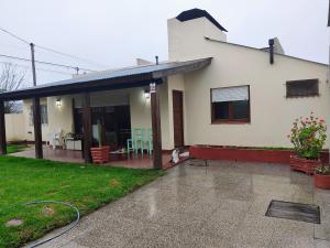 a white house with a dog sitting in front of it at El Quincho de Mariana in Balcarce