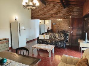 a living room with a couch and a refrigerator at El Quincho de Mariana in Balcarce