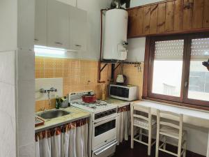 a kitchen with a sink and a stove top oven at El Quincho de Mariana in Balcarce +2 photos