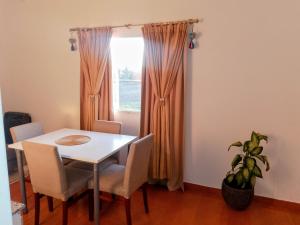 a dining room table with chairs and a window at Depto Muy Patagónico, lindo y cómodo in Trelew