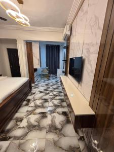 a hotel room with a bed and a tiled floor at KELNESSA Hotel in Obuassi