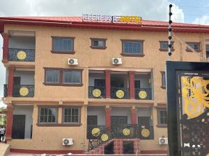 a building with windows and a sign in front of it at KELNESSA Hotel in Obuassi